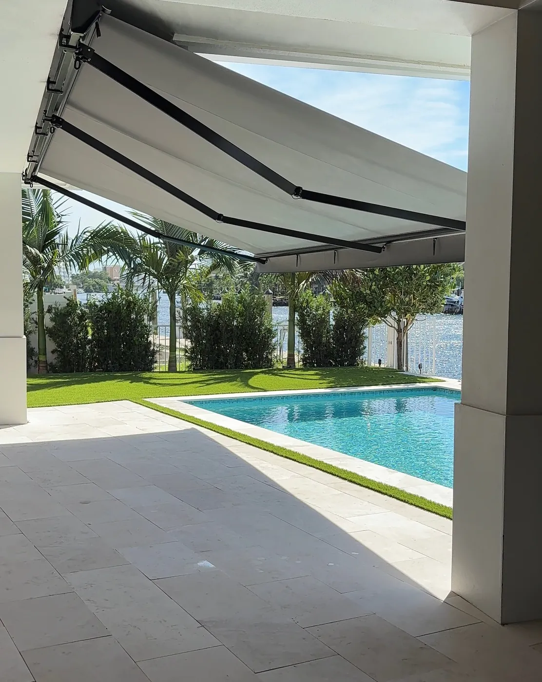 Modern Retractable Awning Shades a Poolside Patio in Sunny Backyard